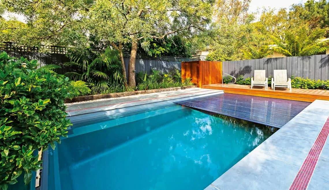 Leisure Pools Denver creates a relaxing backyard spot with a modern pool, comfy chairs, and private fenced space.